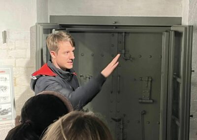 Przewodnik Rafał Sowa przy pancernych drzwiach kontynuuje swoją opowieść
