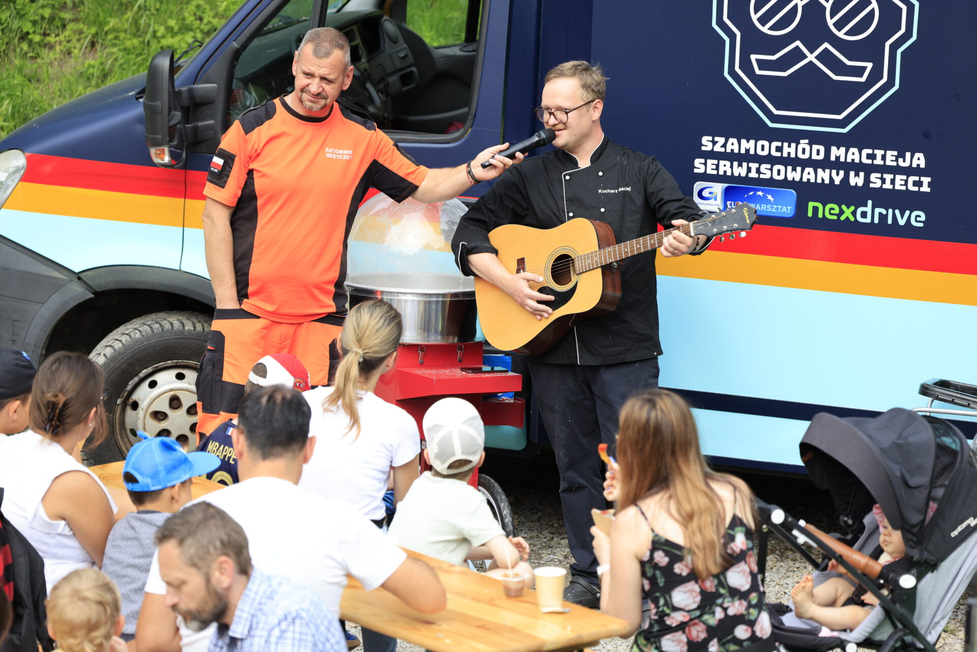 DD.2025.29 kucharz maciej gra na gitarze, ratownik medyczny trzyma mu mikrofon