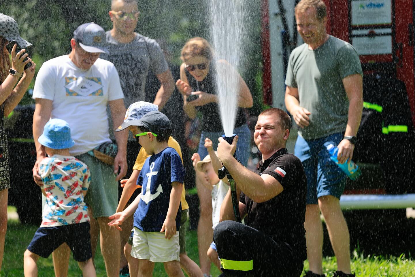 dzień dziecka w Forcie. Strażak pokazuje lanie wody. Leje do góry, dzieciaki śmieją się